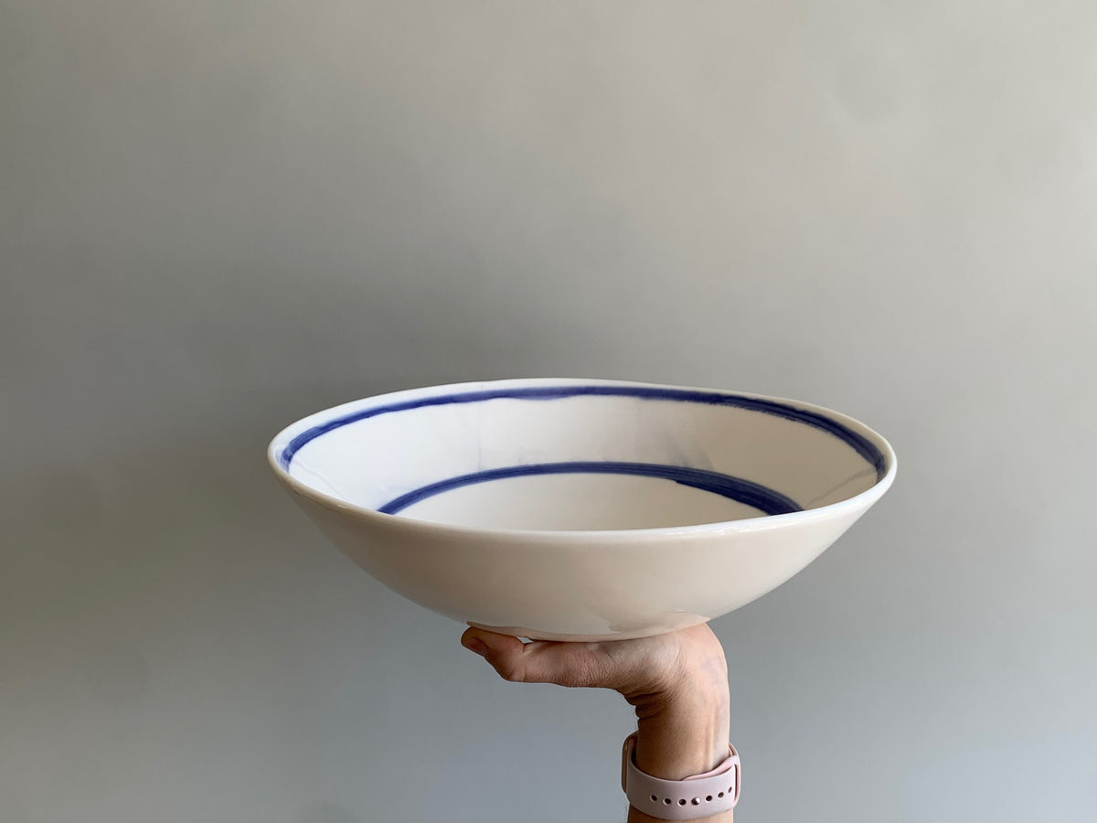 Cobalt blue line handmade porcelain salad bowl held by hand